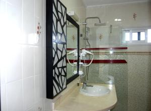 a bathroom with a mirror and a sink at Hotel Al Khaima in Asilah