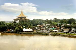 a town next to a river with a large building at Grand Margherita Hotel in Kuching