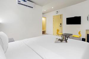 En eller flere senge i et værelse på FabHotel Oasis Yellow Courtyard