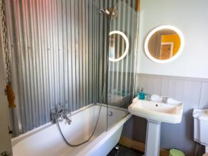ein Bad mit einer Badewanne, einem Waschbecken und einer Dusche in der Unterkunft Pass the Keys Explorers Base Camp in Church Stretton