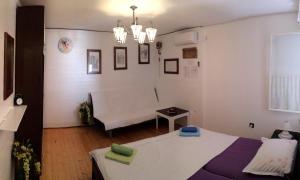 een kamer met een bed en een bank erin bij DVORI CAROLINA in Baška