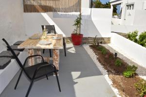 Un pequeño patio con una mesa y sillas. en STELLA'S LUXURY HOUSE, en Batsi