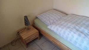 a small bed with a lamp on a night stand at Bachlauf in Nahrendorf