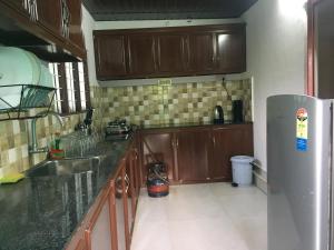 a kitchen with wooden cabinets and a stainless steel refrigerator at Cherai Beach Retreat in Cherai Beach