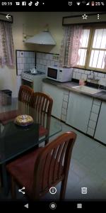una cucina con tavolo, sedie e piano di lavoro di La casita de Ana y Eto a Villa Elisa