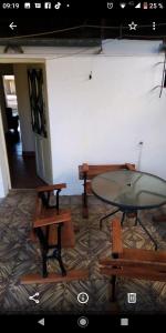 una sala con tavoli, panche e tavolo in vetro di La casita de Ana y Eto a Villa Elisa
