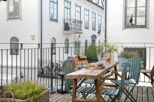 uma mesa de madeira e cadeiras numa varanda em Hotell Repet em Visby