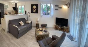 sala de estar con sofá y TV en Mas Eugenie agrandie et rénovée en Six-Fours-les-Plages