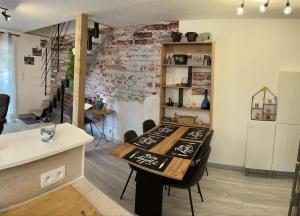 a dining room with a table and a brick wall at Mas Eugenie agrandie et rénovée in Six-Fours-les-Plages