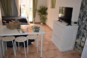 a living room with a tv and a table and stools at Castle H 408 in Los Cristianos