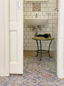 a cat laying on a table under a sink in a bathroom at Casa Chiara in Lipari