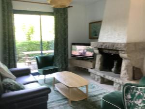 sala de estar con chimenea y TV en Gîte Maez 4 pers 29450 sizun, en Sizun