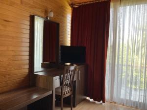 a room with a desk with a television and a window at Kutle Hotel in Cıralı