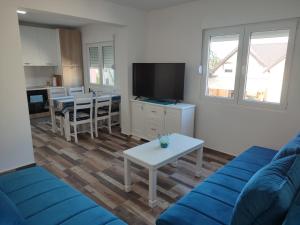 a living room with a blue couch and a table at Apartman DoM in Žabljak