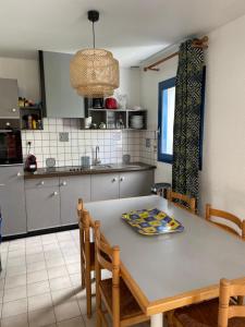 La cocina está equipada con mesa, sillas, mesa y mesa. en Gîte Maez 4 pers 29450 sizun, en Sizun