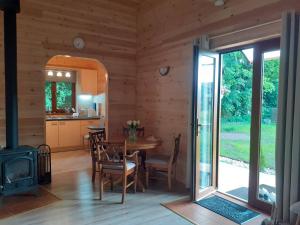 a kitchen and dining room with a stove in a cabin at Forest Edge Lodge in Riga