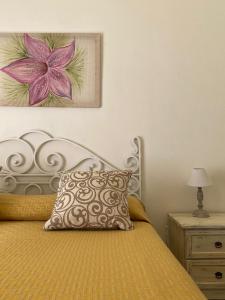 a bed with a pillow and a painting on the wall at Casa Chiara in Lipari