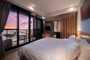 1 dormitorio con cama grande y ventana grande en 拾滬海景會館 澎湖海景民宿, en Kuang-yang
