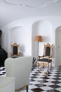 una sala de estar con 2 sillas y una lámpara. en Palazzo Don Salvatore, en Amalfi