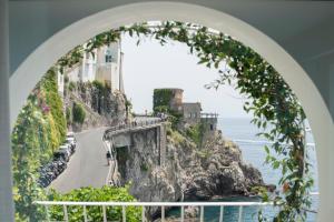 uma vista para a costa amalfi através de um arco em Palazzo Don Salvatore em Amalfi