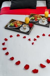 クラクフにあるコモロウスキ ラクジュアリー ゲスト ルームズの食器と赤心の皿が二つあるテーブル