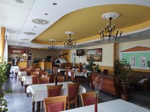 a restaurant with tables and chairs and a yellow ceiling at Hotel Biele Studničky Dargov in Drahov