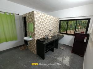 a bathroom with a sink and a toilet in a room at Palolem Sunrise Apartment in Palolem