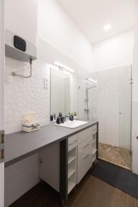 a white bathroom with a sink and a mirror at A37 Awesome Apartments in Budapest