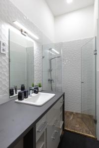 a white bathroom with a sink and a shower at A37 Awesome Apartments in Budapest