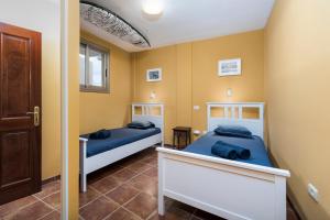 2 łóżka w pokoju z żółtymi ścianami w obiekcie MEDANO4YOU The Penthouse La Jaquita w mieście El Médano