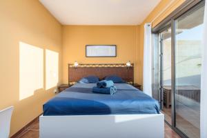 sypialnia z niebieskim łóżkiem z pluszakiem w obiekcie MEDANO4YOU The Penthouse La Jaquita w mieście El Médano