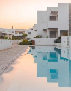 a swimming pool in front of a building at Makrigialos Long Beach Villas - Penthouse 1 in Makry Gialos