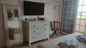 a bedroom with a white dresser with a television on it at Authentic Charm Soltroia in Troia