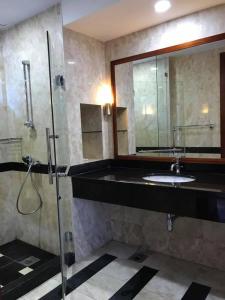 a bathroom with a shower and a sink and a mirror at Garden View Pulai Springs Resort in Skudai