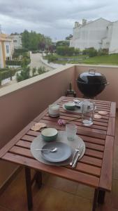 a table with plates and a grill on a balcony at Authentic Charm Soltroia in Troia