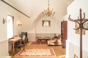 a living room with a chandelier and a table at Schloss Thalheim in Sankt Pölten