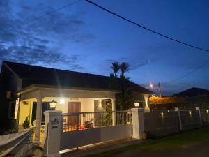 uma casa com uma cerca em frente à noite em MELAKA BEACH VILLA ( B TYPE ) em Malaca
