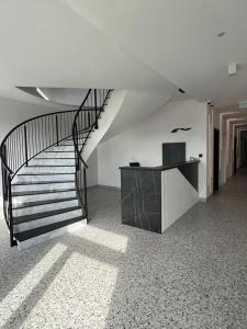 Kľušov的住宿－Apartmány Ambiente，白色客房内的螺旋楼梯,配有书桌