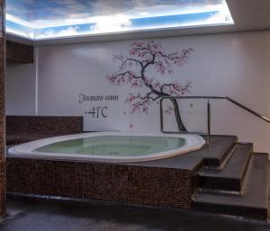 a bath tub with a tree mural on a wall at Lavendel Spa Hotel in Tallinn