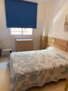 - une chambre avec un lit doté d'un rideau bleu dans l'établissement COSTA MARFIL II - Marina Dor, à Oropesa del Mar