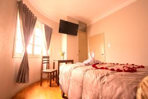 a bedroom with a bed with a stuffed animal on it at Hostal Virreinal AQP in Arequipa