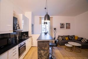 cocina y sala de estar con encimera negra en Smile Apartment en Cannes