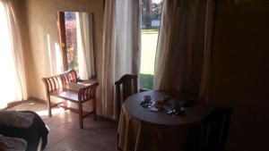 a room with a table and a chair and a window at Mediterráneo Cabañas in Chascomús