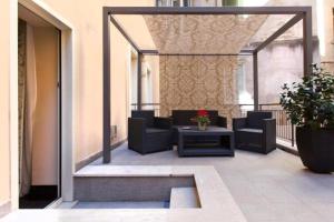 a patio with chairs and a table on a balcony at Trevi Palace Hotel in Rome