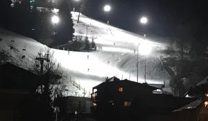 a snow covered ski slope at night with lights at Ski and Lake View Apartment in Zell am See