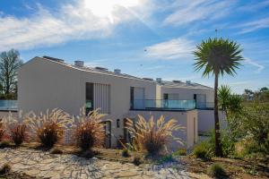 a white house with a palm tree in front of it at Villa Cerrado das Fontainhas SPA in Sintra