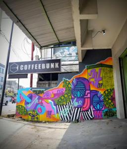 un bâtiment avec des graffitis colorés sur son côté dans l'établissement CoffeeBunk Hostel, à Tangerang