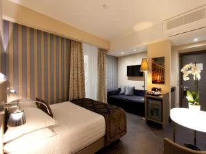 a hotel room with a bed and a couch at Trevi Palace Hotel in Rome