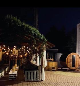 a patio with umbrellas and lights at night at Jantarowy Sen in Jantar