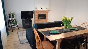 sala de estar con mesa y chimenea en APARTAMENT DWUPOKOJOWY en Ostrowiec Świętokrzyski